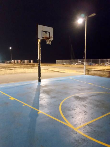 istock Basketball hoop at night with sea by beach Brighton UK 1204219976