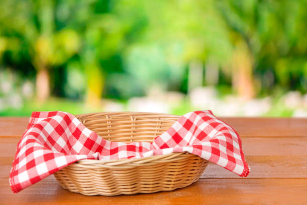 istock Basket with red checkered cloth inside on a wooden table 1204221540