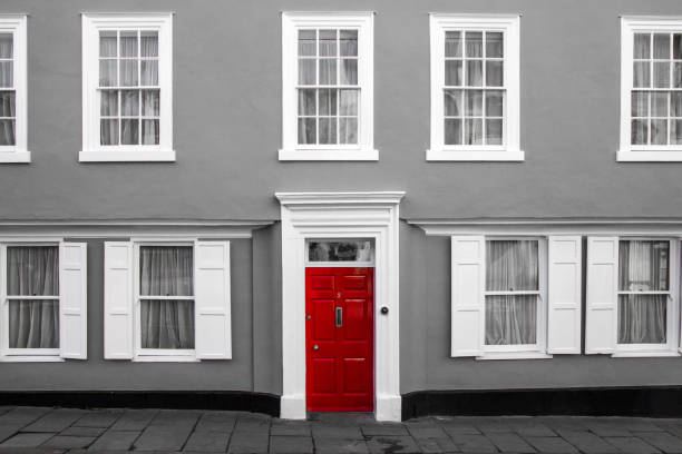 A facade of a traditional village house in Great Britain. Its red door are isolated in a black and white picture. A facade of a traditional village house in Great Britain. Its red door are isolated in a black and white picture. front door photos stock pictures, royalty-free photos & images