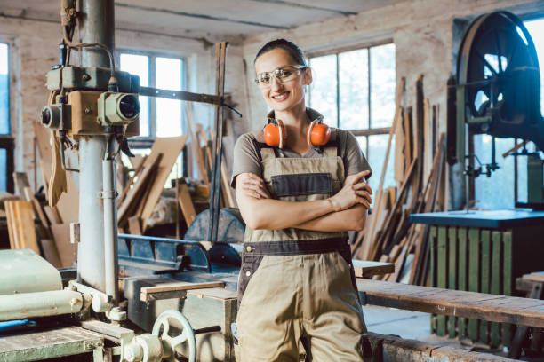 Beautiful woman carpenter in her woodwork workshop Beautiful proud woman carpenter in her woodwork workshop carpenter carpentry craftsperson carving stock pictures, royalty-free photos & images