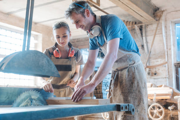 istock Team of carpenters working on the circular saw 1204225995