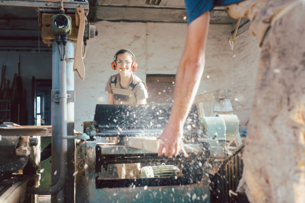 istock Team of carpenters planning wood using a machine 1204226302