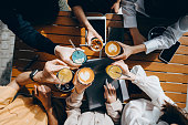 Top angle view of a group of corporate co-workers having drinks with reusable stainless steel straws and celebrating after work