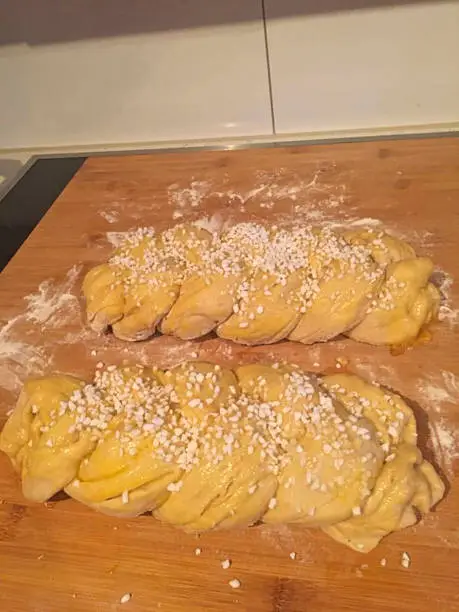 a braided yeast bread with sugar ready for the oven