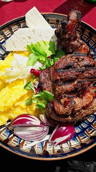 grilled meat with salad and bread on a plate