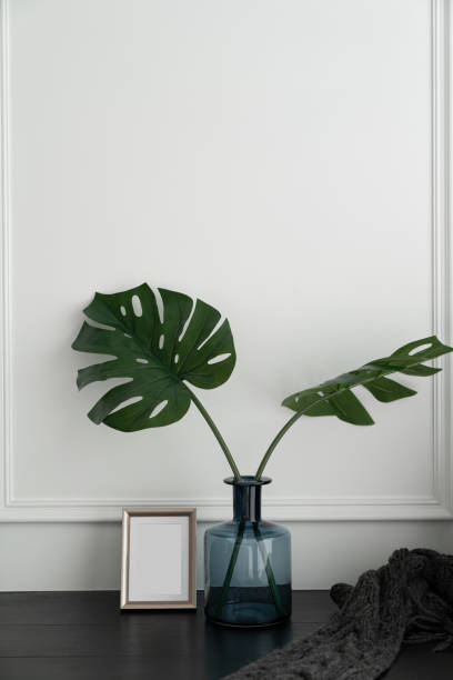 istock Nice artificial plant in blue glass vase with gold stainless frame  setting on black wood table in minimal modern style apartment / residential interior concept / copyspace 1204230573