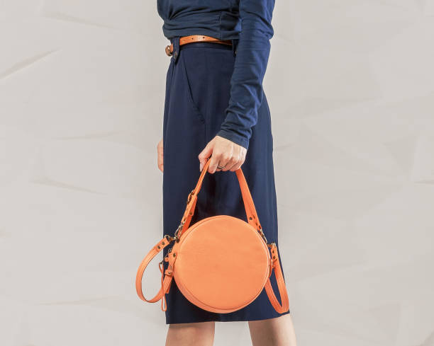 elegante mujer de moda con bolsa redonda naranja - women bag fotografías e imágenes de stock