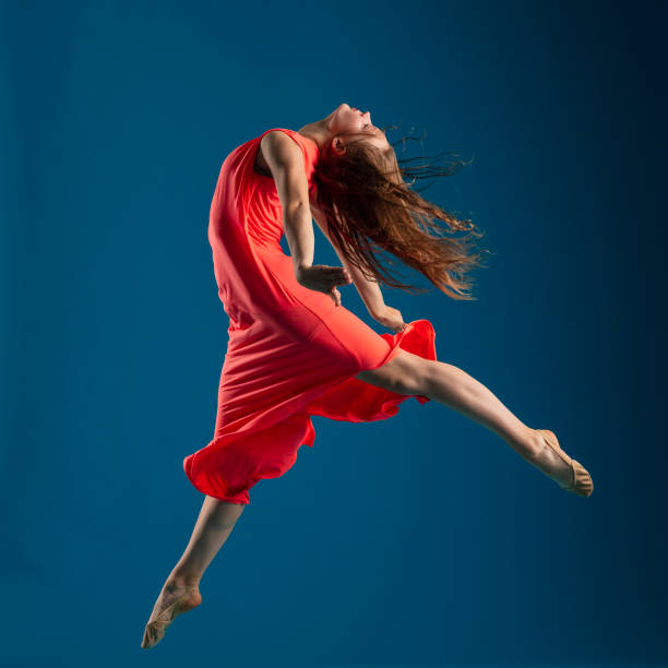 istock Dancer in red dress on blue background 1204235789