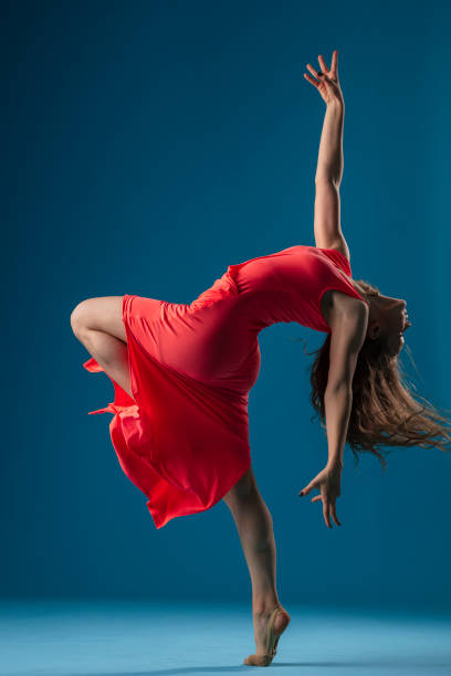 istock Dancer in red dress on blue background 1204235847