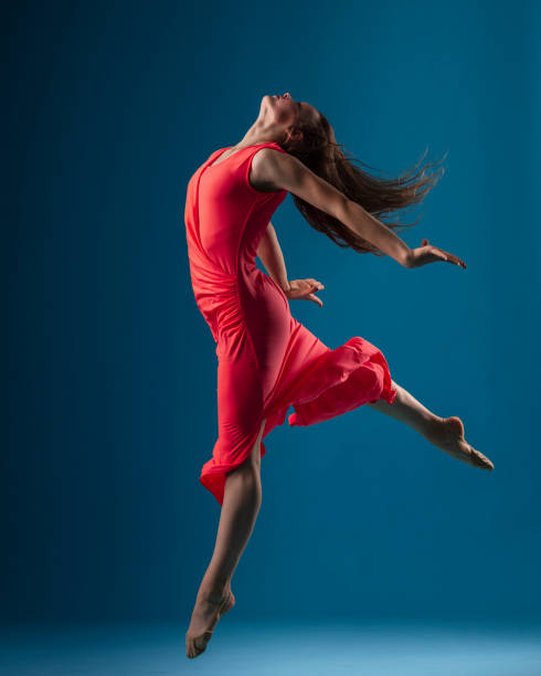istock Dancer in red dress on blue background 1204235893