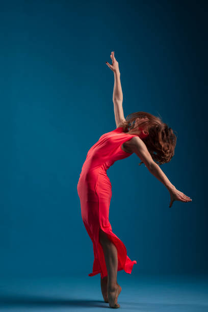 istock Dancer in red dress on blue background 1204235895