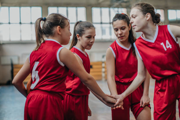 istock Female School Basketball Team Huddling 1204236150