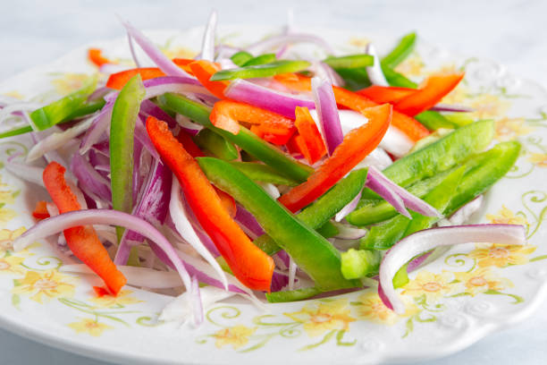 Fresh, healthy sliced green and red pepper, and red onion in preparation for cooking