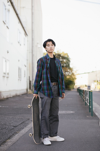 Full Length length portrait of skateboarder on a city street.