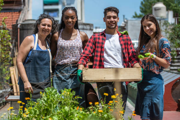 портрет учителя городского садоводства с ее молодыми учениками - vegetable garden urban scene city life community garden стоковые фото и изображения