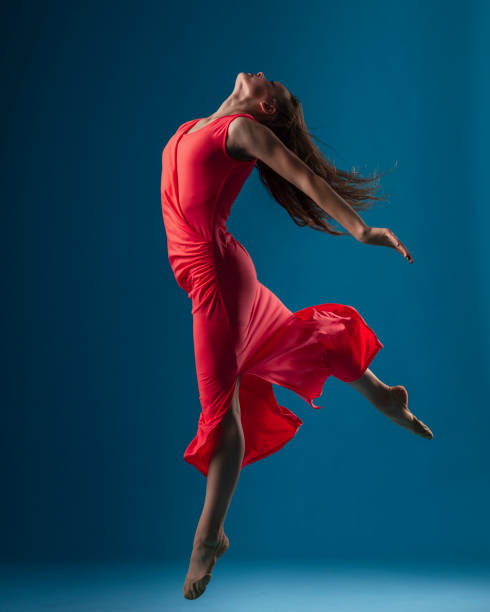 istock Dancer in red dress on blue background 1204236559