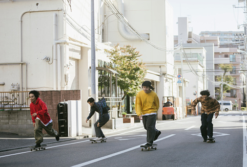 Group of friends skateboarding on city streets.