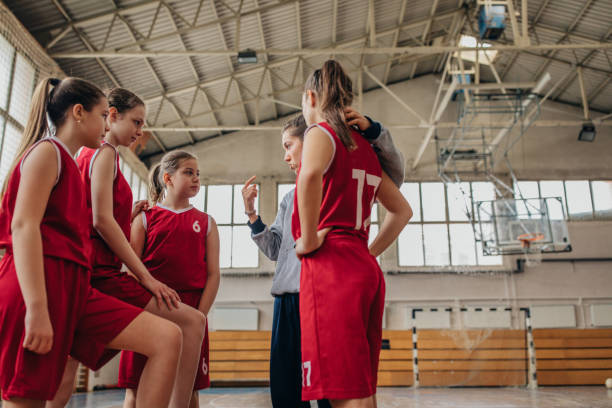 istock Coach standing with basketball team 1204237495