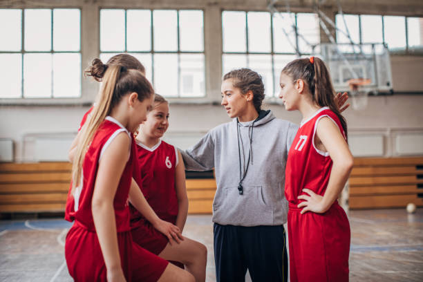 istock Coach standing with basketball team 1204237519