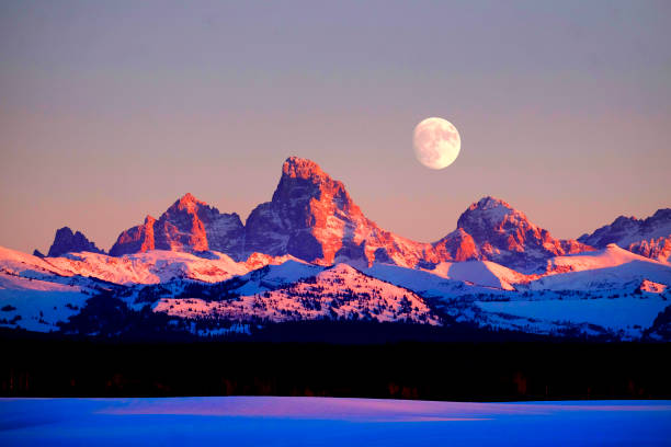 istock Sunset light with alpen glow on Tetons Tetons mountains rugged with moon rising 1204238549