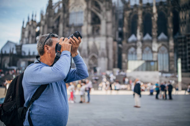 istock Mature man with digital camera on the street 1204239966