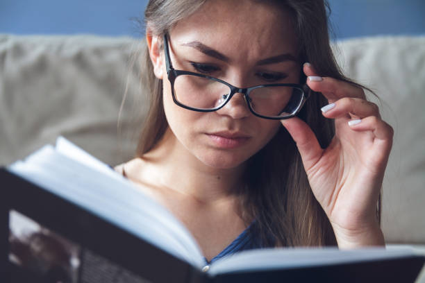 istock Woman with glasses reading a book 1204240323