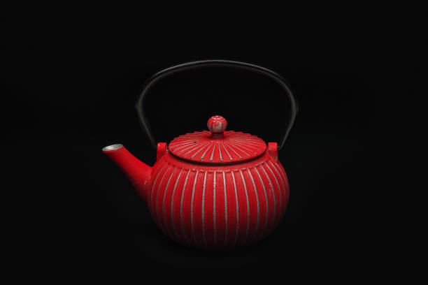 istock Red cast-iron teapot on a black background. 1204244245