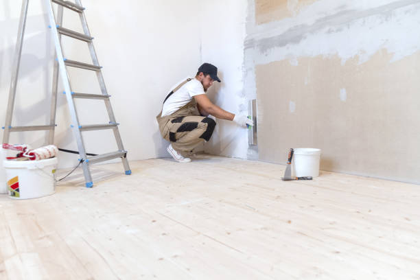 istock Male painter with a putty knife in his hands makes repairs in th 1204244340