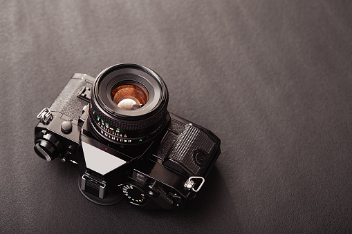 High angle view of a professional vintage SLR analog film camera on black background