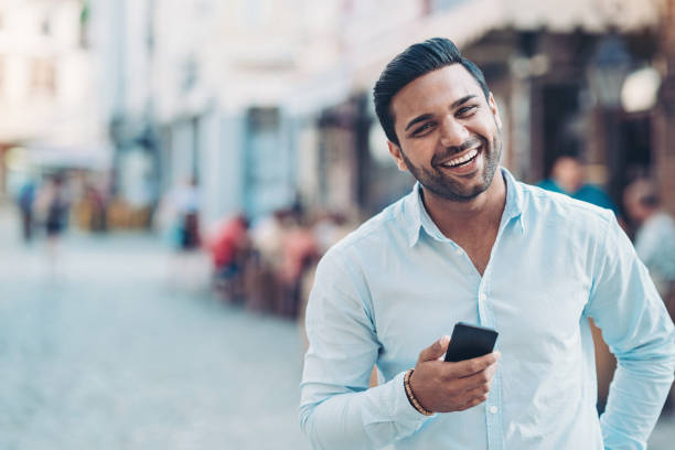 istock Smiling businessman holding a smart phone 1204252139