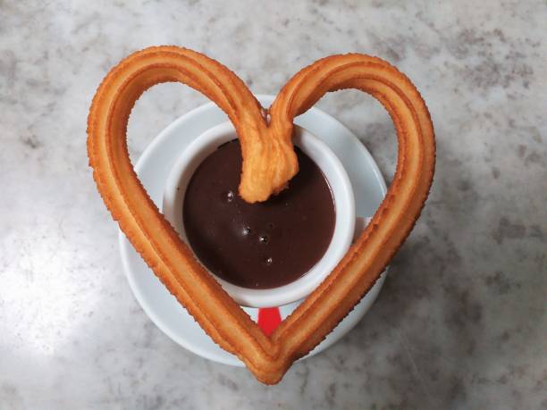 Hot chocolate cup with heart shape of fried-dough pastry stock photo