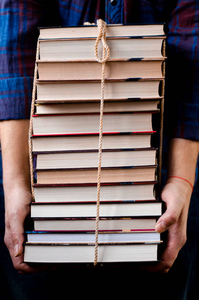 istock A man holds many books tied with a rope 1204254310