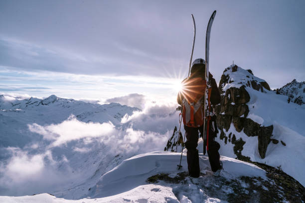 istock Ski mountaineer ascends snowy mountain summit ridge at sunrise 1204254935