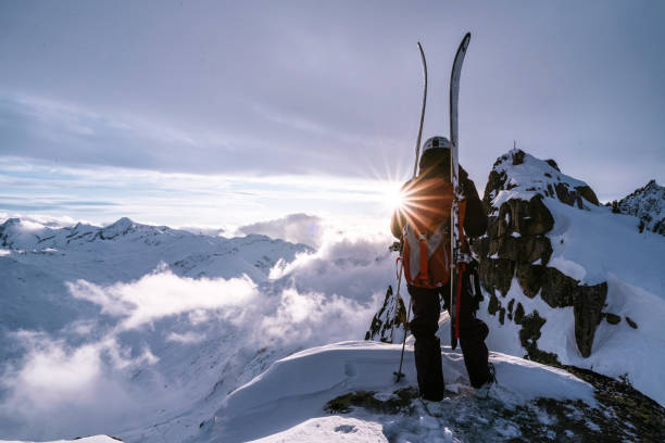 istock Ski mountaineer ascends snowy mountain summit ridge at sunrise 1204254989