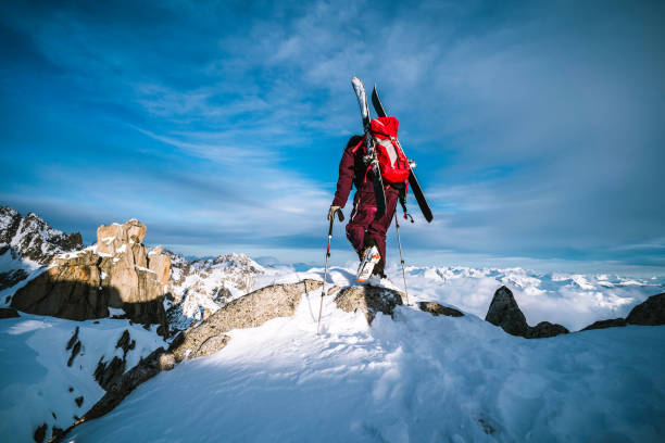 istock Ski mountaineer ascends snowy mountain summit ridge at sunrise 1204255122