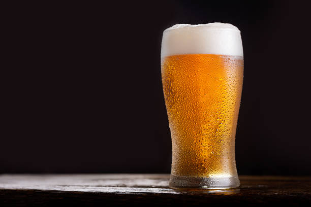 glass of beer on dark background stock photo