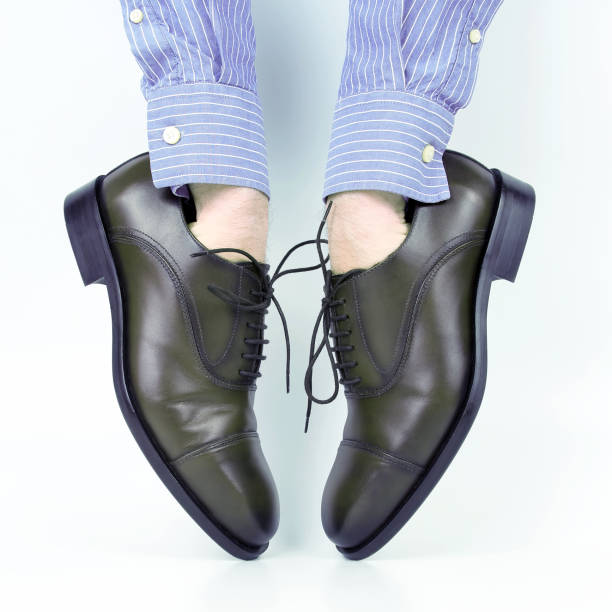 istock Classic brown shoes worn on the hands on a white background 1204258447