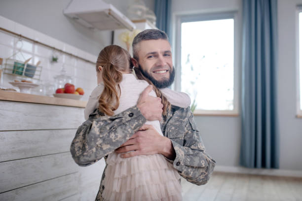 istock Serviceman dad returning home hugging little daughter. 1204259298