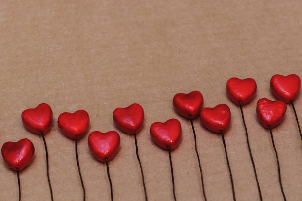 istock Small red hearts lie in a row on a craft background. 1204260437