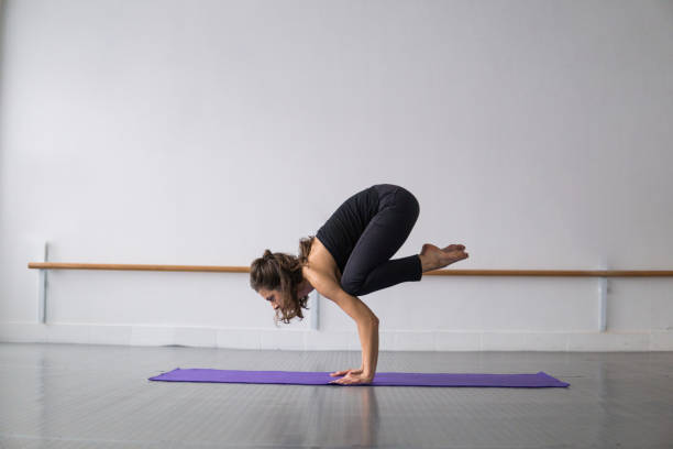 istock Woman doing a crane exercise pose, yoga warm up exercise 1204262955