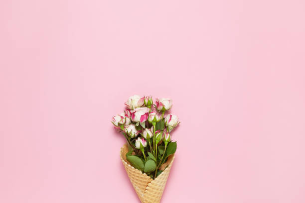 istock Small roses in waffle cone on pink background, copy space. Minimal style flat lay. For greeting card, invitation. March 8, February 14, birthday, Valentine's, Mother's, Women's day concept. Top view 1204263088