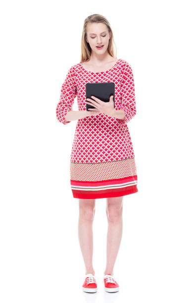 istock Caucasian young women standing wearing dress and using digital tablet 1204264310