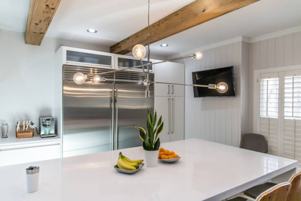 istock spacious large modern white kitchen recently updated with high end appliances, wood floors, picture windows, white cabinets and wood beams 1204265634
