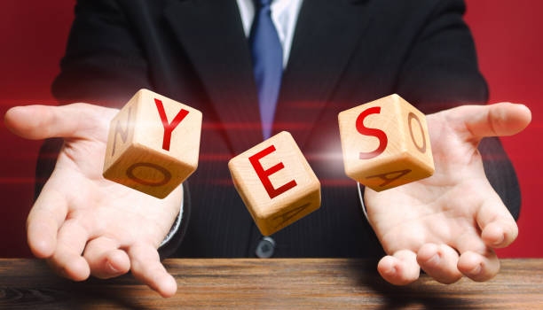 istock Cubes thrown by a man make up word YES. Agreement and acceptance, answer the question. Courage, irresistibility, zeal forwards, consent. Confirmation and approval. Important decision. Correct answer 1204265692