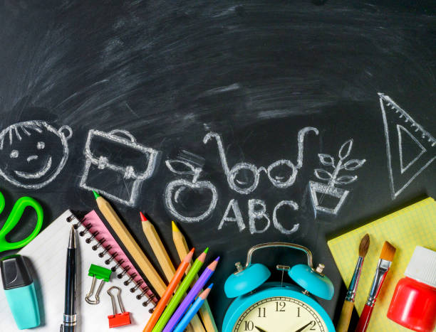 istock School supplies on blackboard background with chalk drawings on it. Copy space 1204266238