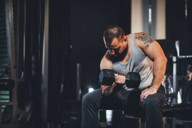 istock Muscular man doing exercises with dumbbells 1204268874