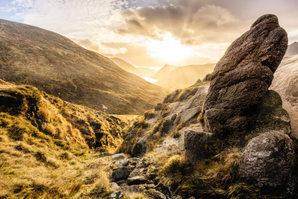 istock Large boulder and valley with water reservoir, dramatic sunset with sunrays. Mourne Mountains 1204268992