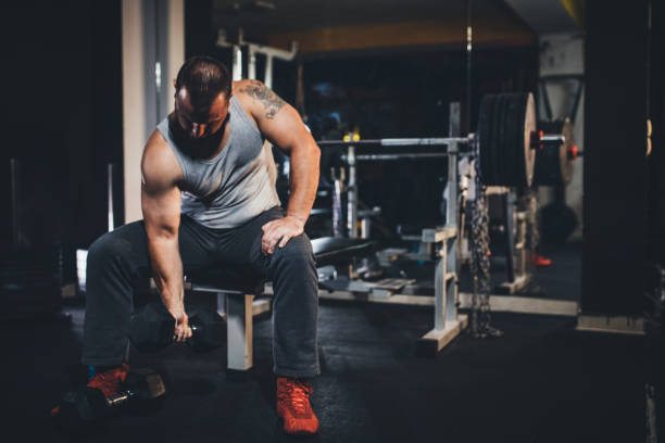 istock Muscular man doing exercises with dumbbells 1204269098