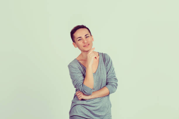 independent and happy. half length body woman short hair girl boy alike trans-gender looking at you camera smile on face isolated light green gray background - half smile imagens e fotografias de stock