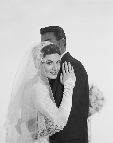 Vintage photo from the early 50s, young couple posing for their studio wedding formal portrait